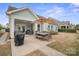 Inviting outdoor patio with dining table, seating, umbrella, and grill, perfect for entertaining at 13115 Union Square Dr, Huntersville, NC 28078