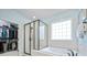 Modern bathroom featuring a glass shower, soaking tub, window, and walk-in closet at 13115 Union Square Dr, Huntersville, NC 28078