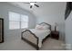A cozy bedroom with neutral colors, plush bedding, and a ceiling fan at 13115 Union Square Dr, Huntersville, NC 28078