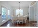 Bright dining room with sunflowers, white wooden chairs, and natural light through patio doors at 13115 Union Square Dr, Huntersville, NC 28078