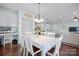 An open-concept dining room with white wooden furniture and views of the kitchen and living room at 13115 Union Square Dr, Huntersville, NC 28078