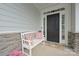 Charming front door with white bench, colorful pillows, and decorative stonework at 13115 Union Square Dr, Huntersville, NC 28078