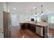 Open-concept kitchen with dark cabinets, granite countertops, and stainless steel appliances at 13115 Union Square Dr, Huntersville, NC 28078