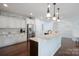 Well-lit kitchen featuring white cabinets, stainless steel appliances, and a granite-topped island at 13115 Union Square Dr, Huntersville, NC 28078