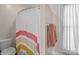 Bright bathroom featuring a colorful shower curtain, white trim, and a neatly hung towel at 1321 South Point Rd, Belmont, NC 28012
