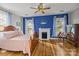 Bedroom with wood flooring, bright blue accent wall, fireplace, and multiple windows with natural light at 1321 South Point Rd, Belmont, NC 28012