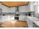 Bright kitchen with stainless steel appliances, white cabinets, and beautiful wood ceiling at 1321 South Point Rd, Belmont, NC 28012