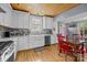 Well-lit kitchen featuring white cabinets, stainless steel appliances, and hardwood flooring at 1321 South Point Rd, Belmont, NC 28012