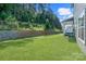 Lush backyard featuring a retaining wall, grassy lawn, and outdoor patio furniture at 1390 Cedardale Ln, Denver, NC 28037