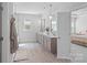 Bright bathroom featuring a double vanity, pendant lights, wood-look tile, and a view into the main bedroom at 1390 Cedardale Ln, Denver, NC 28037