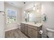 Bathroom featuring a double vanity, large mirror, and wood-look tile flooring at 1390 Cedardale Ln, Denver, NC 28037
