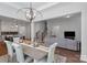 Dining area with a large table and modern lighting, seamlessly connected to the kitchen and living room at 1390 Cedardale Ln, Denver, NC 28037