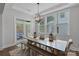 Well-lit dining area with a large wooden table, bench seating, and a modern chandelier at 1390 Cedardale Ln, Denver, NC 28037
