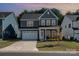 Two-story gray home with white trim, well-kept lawn, attached garage, and a cozy front porch at 1390 Cedardale Ln, Denver, NC 28037