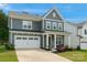 Charming two-story home with grey siding, white trim, attached garage, and manicured landscaping at 1390 Cedardale Ln, Denver, NC 28037