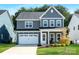 Charming two-story home with gray siding, white trim, a well-manicured lawn, and an attached garage at 1390 Cedardale Ln, Denver, NC 28037