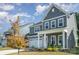 View of the gray two-story house with white trim, and a manicured front lawn and landscaped flower beds at 1390 Cedardale Ln, Denver, NC 28037