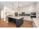 Bright kitchen with white cabinets, stainless steel appliances, dark island, and stylish pendant lighting at 1390 Cedardale Ln, Denver, NC 28037