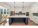 Modern kitchen with white cabinets, stainless steel appliances, tile backsplash and a large center island at 1390 Cedardale Ln, Denver, NC 28037