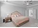 Cozy main bedroom with a comfortable bed, soft carpet, and neutral decor with a peek into the adjoining bathroom at 1390 Cedardale Ln, Denver, NC 28037
