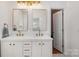Elegant bathroom featuring double sinks, gold fixtures, and plenty of storage space with clean white cabinets at 14457 Adair Manor Ct, Charlotte, NC 28277
