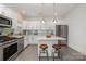 Contemporary kitchen boasts stainless steel appliances, marble countertops, and ample cabinet space at 14457 Adair Manor Ct, Charlotte, NC 28277
