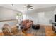 Bright living room featuring a plush pink sofa, decorative chair, and light hardwood flooring at 14457 Adair Manor Ct, Charlotte, NC 28277