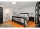 Bright main bedroom with hardwood floors, a large bed, and an ensuite bathroom, providing a relaxing retreat at 14457 Adair Manor Ct, Charlotte, NC 28277