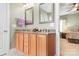 Light filled bathroom with dual sinks, granite counters and views into the main bedroom at 14541 Holly Springs Dr, Huntersville, NC 28078