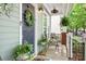 Inviting front porch with seating, potted plants, a charming wreath, and stylish decorative touches at 14541 Holly Springs Dr, Huntersville, NC 28078