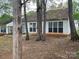 A view of the backyard, showcasing mature trees and a patio area at 1507 Rumstone Ln, Charlotte, NC 28262