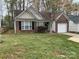 A cozy brick home with a well-manicured front lawn, featuring a single-car garage at 1507 Rumstone Ln, Charlotte, NC 28262