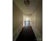 Long hallway with dark wood floors leading to a bright living area and several doors at 1507 Rumstone Ln, Charlotte, NC 28262