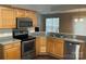 Kitchen featuring wooden cabinets, stainless steel appliances, and a granite countertop at 1507 Rumstone Ln, Charlotte, NC 28262