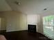 Living room with a decorative fireplace and natural light streaming through the window at 1507 Rumstone Ln, Charlotte, NC 28262