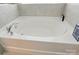 Close up of soaking tub with tile surround and chrome fixtures at 1578 Whitman Ct, York, SC 29745