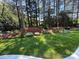 Beautiful backyard features manicured lawn, mature trees, and carefully landscaped flower beds at 17408 Summer Place Dr, Cornelius, NC 28031