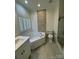 A bathroom has a tiled accent wall above a soaking tub and white-tiled walls at 17408 Summer Place Dr, Cornelius, NC 28031