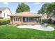 Well-kept brick house with a screened-in porch and cozy patio area surrounded by lush landscaping at 17408 Summer Place Dr, Cornelius, NC 28031