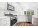 Bright kitchen with stainless steel appliances, white cabinetry, and a modern backsplash at 17408 Summer Place Dr, Cornelius, NC 28031