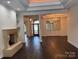 Open-concept living room with fireplace, hardwood floors, and elegant chandelier at 17408 Summer Place Dr, Cornelius, NC 28031