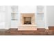 Beautiful stone fireplace in a living room with dark hardwood floors and built-in shelving at 17408 Summer Place Dr, Cornelius, NC 28031