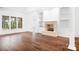 Bright living room featuring hardwood floors, a stone fireplace, and built-in shelving at 17408 Summer Place Dr, Cornelius, NC 28031