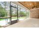 Relaxing screened porch with brick accents and wood ceiling overlooks the serene backyard and lush landscaping at 17408 Summer Place Dr, Cornelius, NC 28031