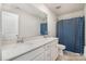 Well-lit bathroom featuring double sinks, a white countertop, and a stylish blue and white striped shower curtain at 17502 Snug Harbor Rd, Charlotte, NC 28278