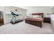 Bright bedroom features a treadmill next to a window and a wooden bed frame at 17502 Snug Harbor Rd, Charlotte, NC 28278