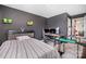 Modern bedroom with dark gray walls, a striped bed, and a gaming desk setup at 17502 Snug Harbor Rd, Charlotte, NC 28278