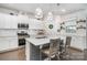 Bright kitchen with white cabinets, stainless steel appliances, an island with seating, and hardwood floors at 17502 Snug Harbor Rd, Charlotte, NC 28278