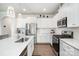 Bright kitchen features stainless steel appliances, gas range, white cabinets, countertops, and hardwood flooring at 17502 Snug Harbor Rd, Charlotte, NC 28278