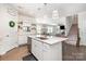 Spacious kitchen with white cabinets, an island featuring a sink, stainless steel appliances, and hardwood flooring at 17502 Snug Harbor Rd, Charlotte, NC 28278